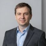 Профессиональный портрет уверенного российского бизнесмена на размытом нейтральном фоне в студийном освещении